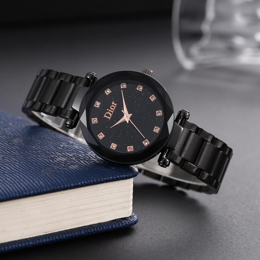 Black Dior watch on a book with a blurred background